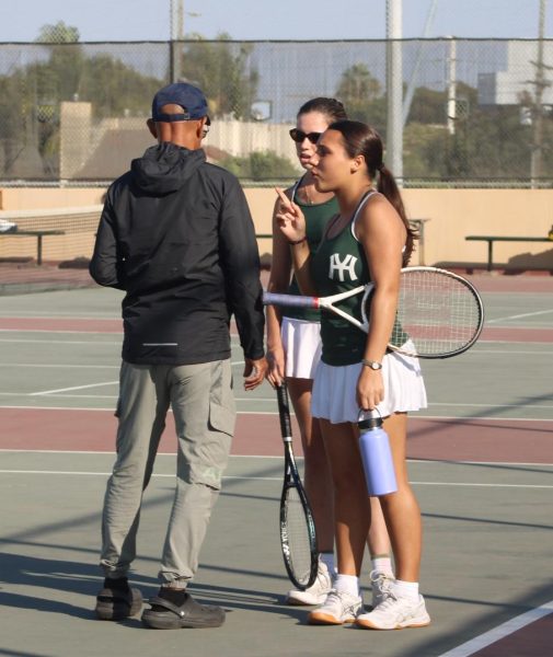 Tennis players have a pep talk with Coach Gaiter.