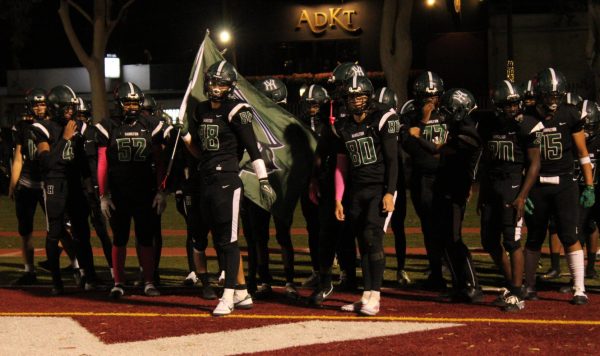 Hami's football team runs out during the pregame routine.