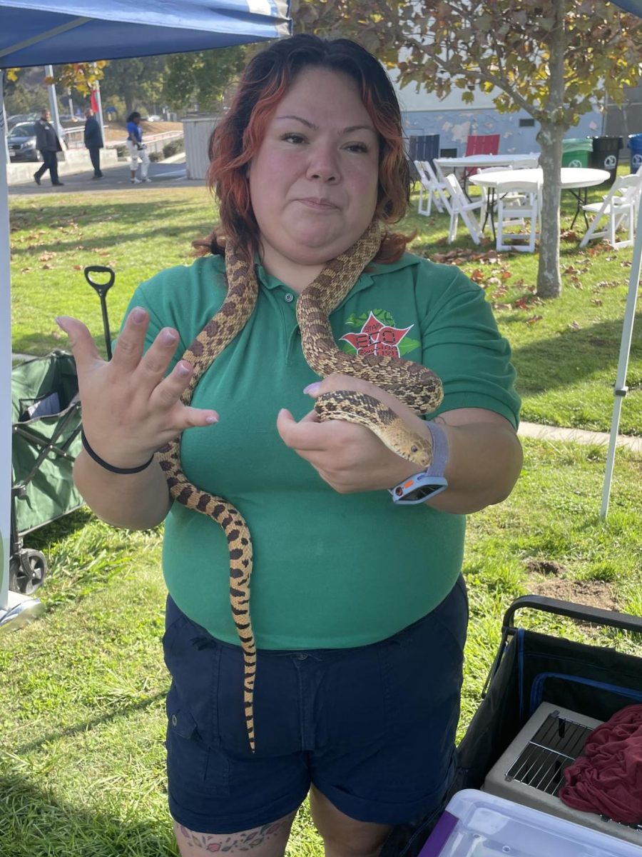 Susan Estrada, a reptile expert, holds a snake around her neck.
