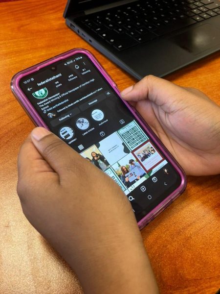 A Hamilton student scrolls on their phone during class.