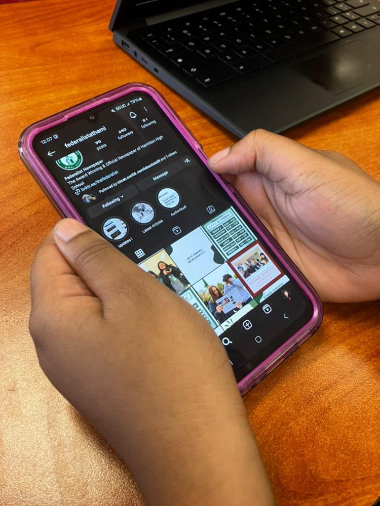 A Hamilton student scrolls on their phone during class.