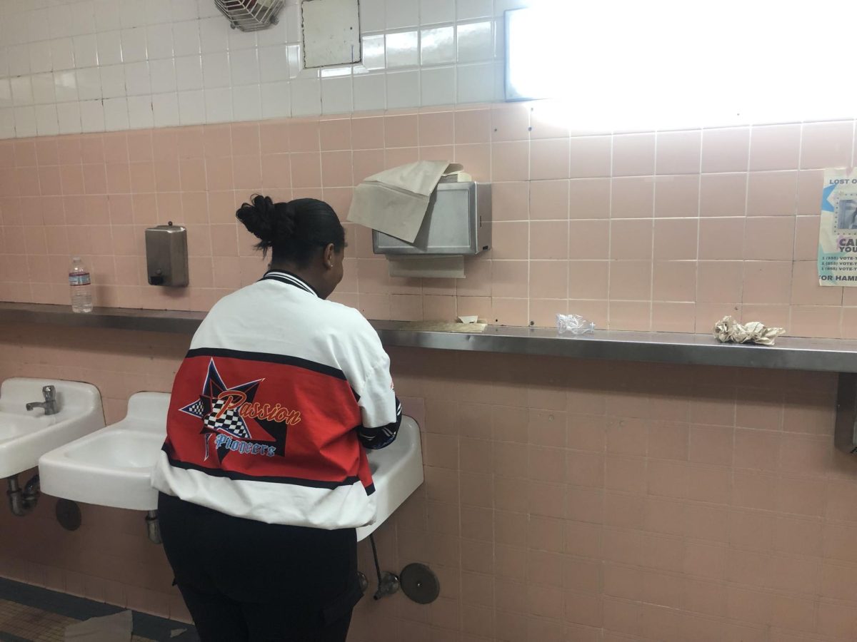 A student washes her hands in the Humanities bathroom. 