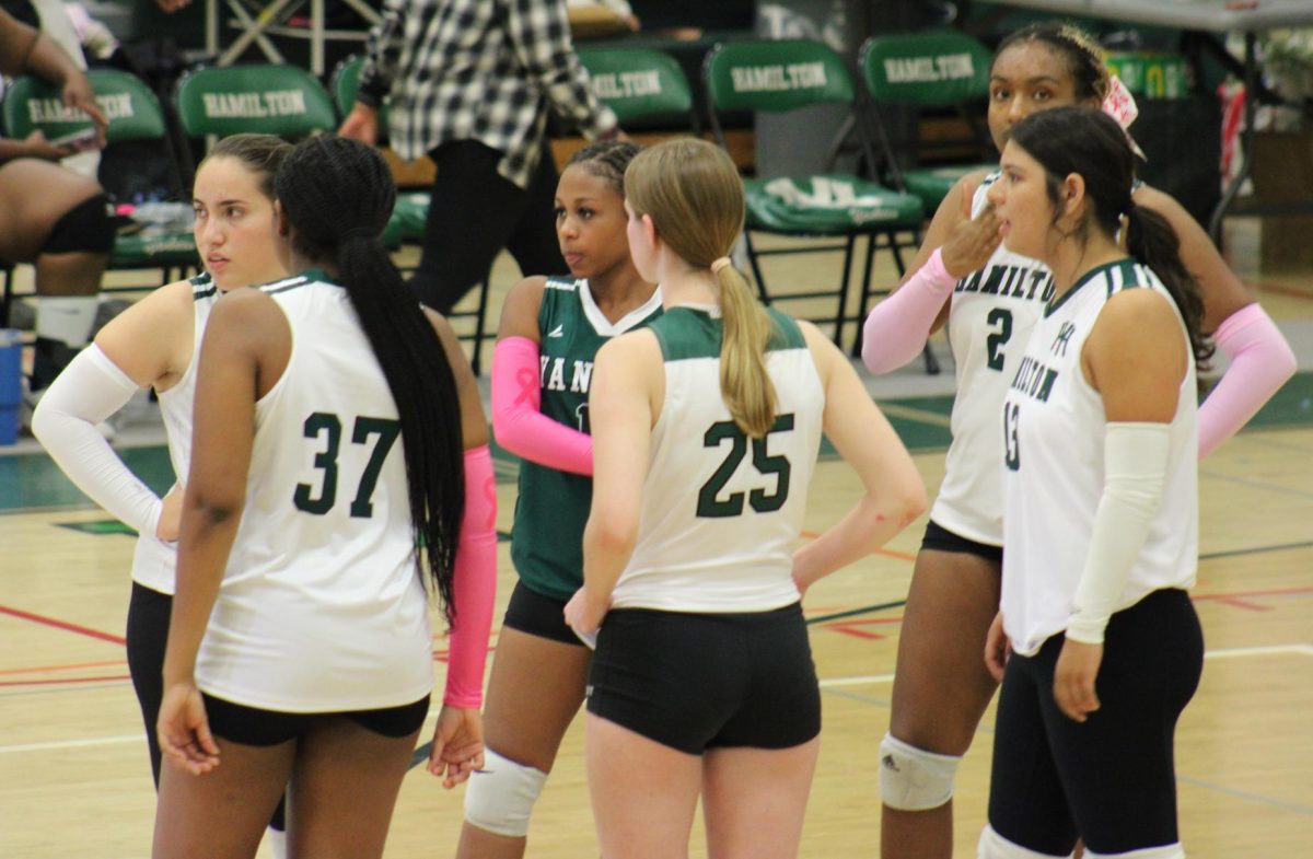 Girls volleyball have a last huddle before their senior night begins.