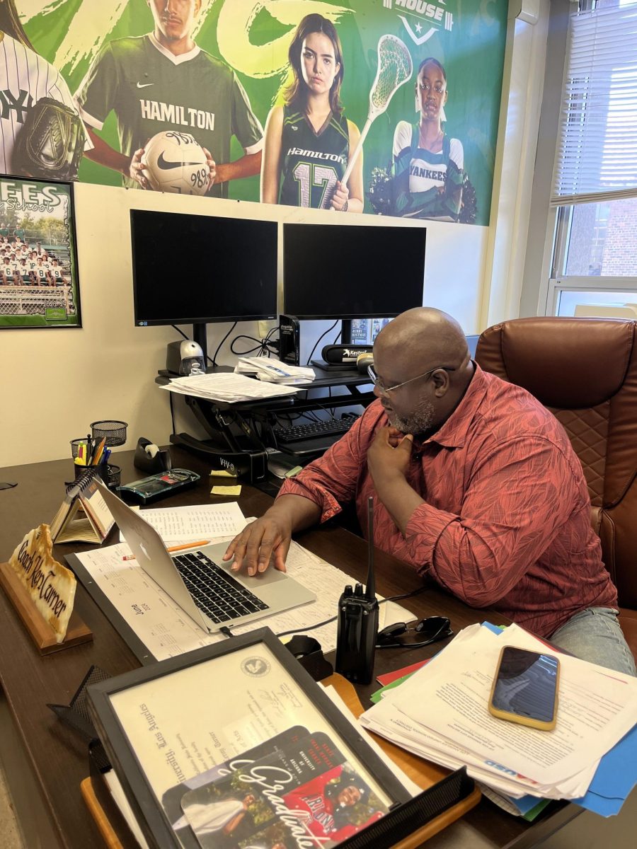 Mr. Turner works at his desk for the athletics department.