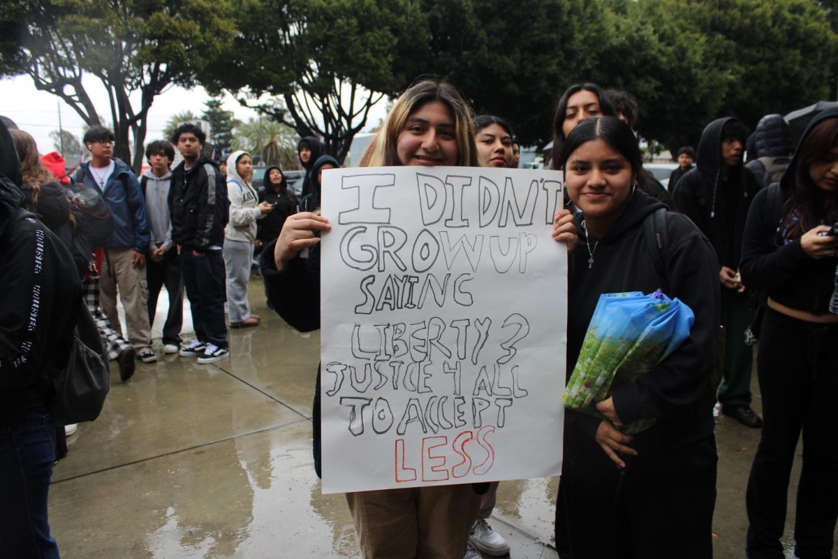 Valerie Martinez and Kimberly Luis display a sign demanding justice.