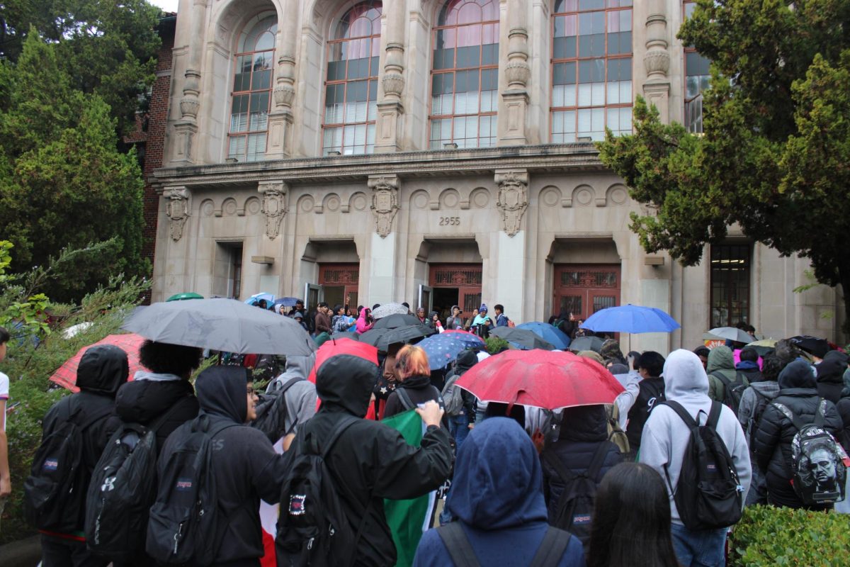 Students gather in the pouring rain to begin the protest.