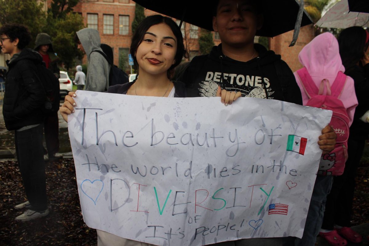 Hillary Melgar and Eddie Garcia display a poster celebrating diversity.