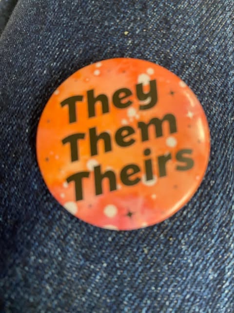 They/Them/Theirs pin depicting the pronouns that one might like to be addressed by.