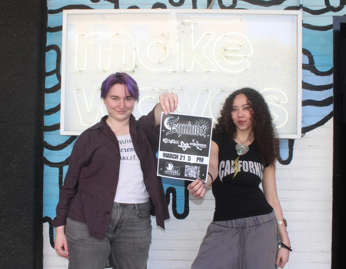 Lila Abercrombie and Kayla Pincus pose with the poster for Equinox in front of the Make Waves classroom.