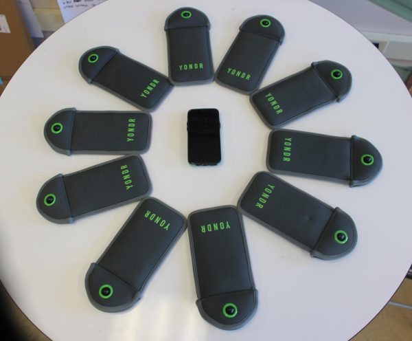 A phone sits between Yondr pouches as a representation of the phone ban's impact. 