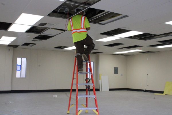 Construction worker completing the theater classroom bungalow.