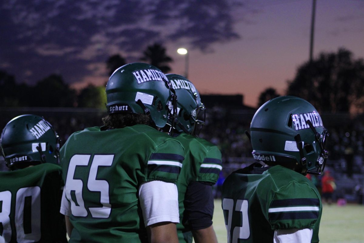 Football players wait for the sun to set in order to start the game.