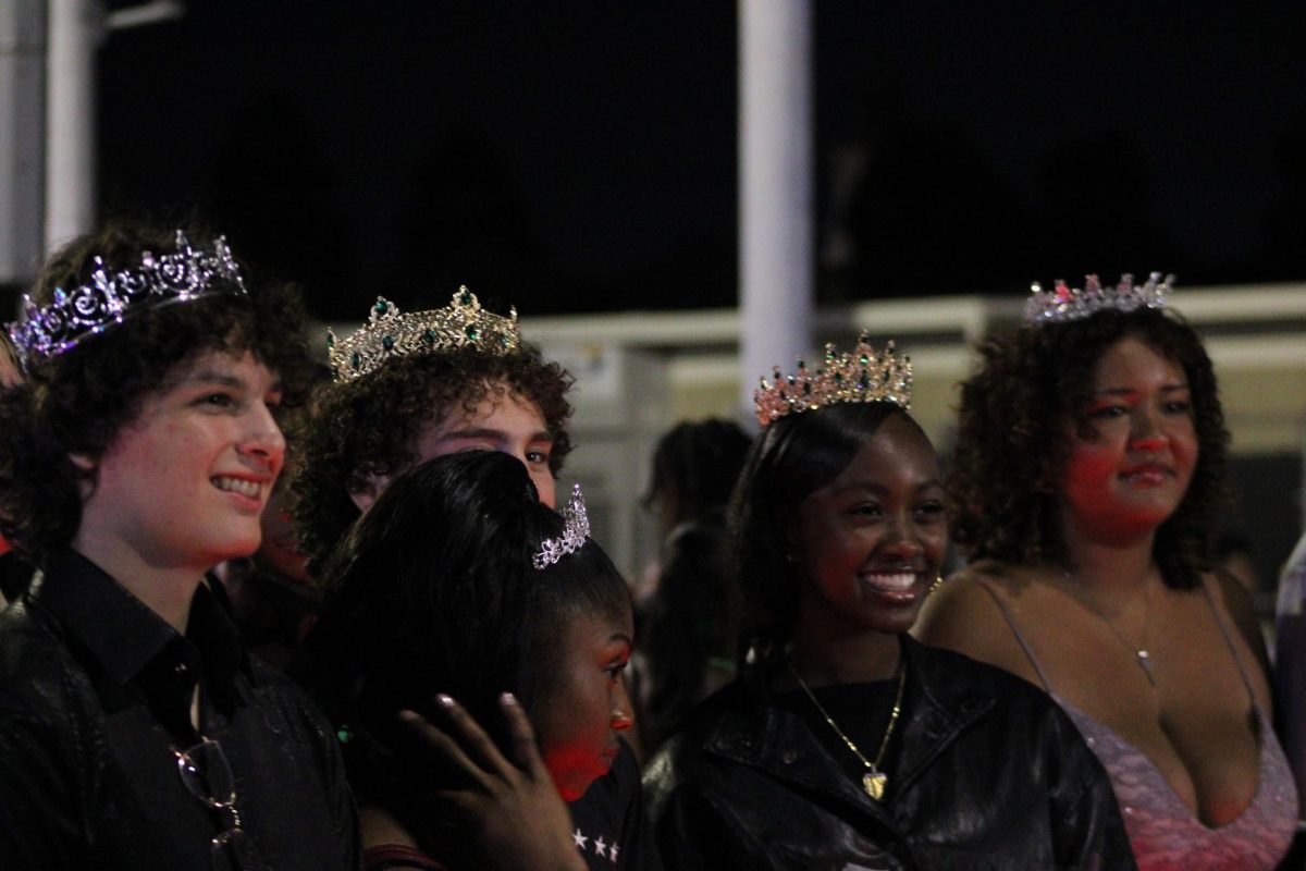Homecoming royalty stands together to pose for photos. 