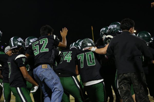 Players embrace one another as the game ends in a win for Hamilton. 