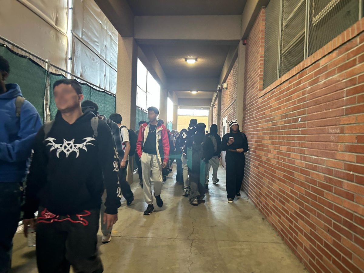 Students walking through the walkway next to the A building that connects the left and right side of the school.