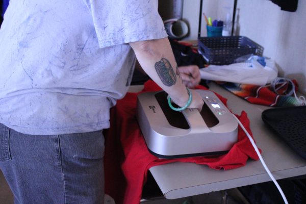 Ceramics teacher Mx. Donabedian presses t-shirts with a Hami UTLA logo to prepare for tomorrow's possible strike.